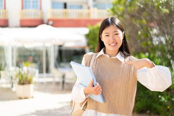 Wall Mural - Pretty Chinese student woman at outdoors with surprise facial expression