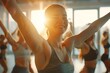 beautiful woman in sportswear enjoy dancing in fitness studio lit by natural light through windows in fitness class. blur group of happy fitness member dancing at background