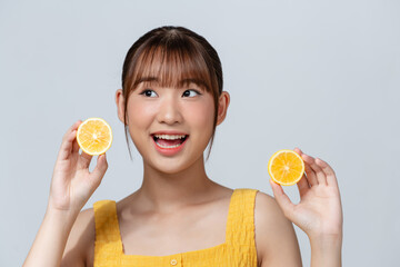 Cheerful feminine girl, natural clear skin, girl with two lemon slices, isolated on a white background