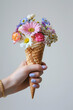 hand holding flowers in ice cream cornet