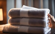 Close-up of Hand professional chambermaid putting stack of fresh towels in hotel room