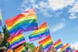 A group of people holding rainbow flags in the air