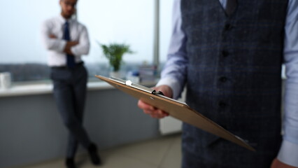 Wall Mural - Male clerk arm in suit and tie with paper clipped to pad at office workplace closeup. Strike bargain for profit white collar motivation union decision corporate sale insurance agent purchase