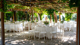 Fototapeta Perspektywa 3d - A wedding with white chairs and tables under trees