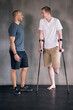 © peopleimages.com - Physiotherapy, crutches and man with disability in healthcare center for walking, muscle strength and coach for support. Amputee, exercise and physiotherapist for physical therapy with rehabilitation