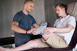 © peopleimages.com - Amputee, medical and physiotherapist with man for rehabilitation in clinic for physical therapy. Healthcare, professional and patient with disability for consultation, help and check in health center