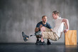 © peopleimages.com - Trainer, person with a disability and prosthetic leg and dumbbell in physiotherapy, studio and gym ball. Male people, physiotherapist and amputee for wellness, fitness and exercise in sports center