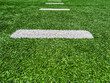 Football Field Turf. Bright green turf football field surface with white yard line markings. Surface level perspective.