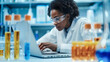 Researcher using computer while working with samples Chemicals. Scientist Woman Working with Laptop in The Laboratory