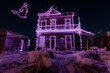 Neon wireframe ghost above abandoned saloon in the desert isotated on black background.