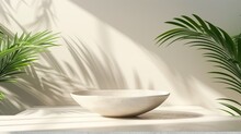 A White Bowl Sits On A Table In Front Of A Wall With Green Leaves
