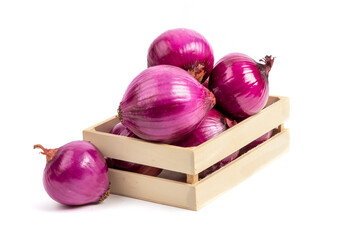 A small wooden crate overflowing with red cooking onions isolated on white