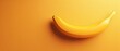   A yellow banana resting atop a yellow backdrop beside a yellow wall with a shadow of the fruit