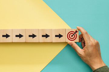 Wall Mural - Concept of objective target, business success growth increase up and economic improvement. Hand hold wooden cube with icon target and arrows pointing up to target