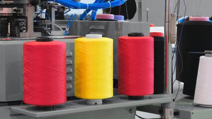 Aufkleber - Three different colored yarns are displayed on a machine. The machine is used to create various types of textiles