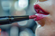 Close-up of lipstick being applied to lips with a fine brush, with lens flare