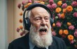 Close-up portrait of senior man with headphones listening to music.