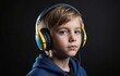 Young boy with black hair wearing headphones on black background