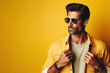 Mature men beauty, eyewear concept. Portrait of an active 30-year-old man posing on yellow background. Fashion style. Copy-space. Studio shot