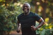 Happy black man running in park with music, smile and mockup in nature, garden and workout. Senior male, outdoor runner and motivation for fitness, energy and healthy exercise training with earphones