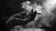 Image of cigarette in man hand with smoke.