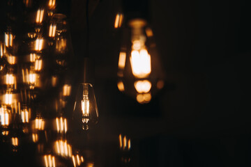 Warm light bulb hanging on dark background