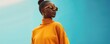 © AnnaN - banner of a beautiful model with her hair in a bun, in a bright orange-yellow knitted sweater, sunglasses with orange frames and stylish earrings on a heavenly colour background, fashion photorealism