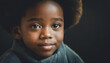 A sweet close up portrait of a black boy with green eyes, dark background, shallow depth of field - portraits of real people authenticity; children of earth
