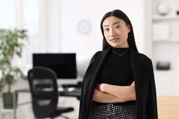 Canvas Print - Portrait of smiling businesswoman with crossed arms in office. Space for text