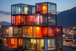 © Ongushi - A colorful of shipping containers has been transformed into a unique residential building. The building is located in an urban setting, surrounded by trees and a street.