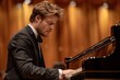 Male pianist performs classical music on grand piano in concert hall with warm lighting