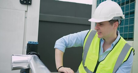 Wall Mural - A Engineer man looking inspecting maintenance insulated pipelines valve pump control on the roof at an industrial site, serious stressed face