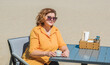 Vacation mood. Plus size happy mature lady wear yellow shirt and blue pants at beach , spring - summer clothes collection