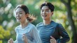 Two young adults jogging together in a park, showcasing health and fitness with a smile