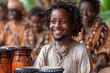 Man With Dreadlocks Smiles in Front of Group of African Drums