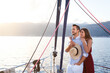 Couple in love traveling on yacht. Happy travelers relaxing and enjoying sunset and summer vacation by sea. Intimate romantic date on sailboat. Journey with beautiful landscape, view