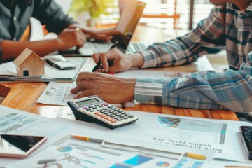 Poster - A dynamic team intensely discusses financial strategies, analyzing data graphs and reports on a well-lit office table
