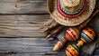 Cinco de Mayo themed featuring a Mexican sombrero on a colorful serape blanket against a wooden background, copy space