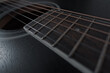 Acoustic guitar with black soundboard close-up