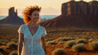 Bellissima donna con capelli ricci e rossi sorride felice al tramonto durante un trekking in vacanza nella Monument Valley negli Stati Uniti d'America