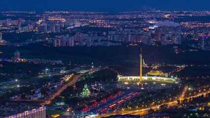 Poster - Aerial top view of Moscow city day to night timelapse after sunset. From the observation platform of the business center. Illuminated Victory Museum at park on Poklonnaya Hill. Traffic on Kutuzov ave