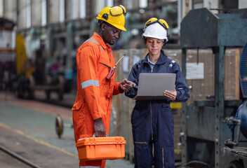 Wall Mural - Engineer supervisor uses laptop for train diagnostics, maintenance, and CO2 reduction discussions.