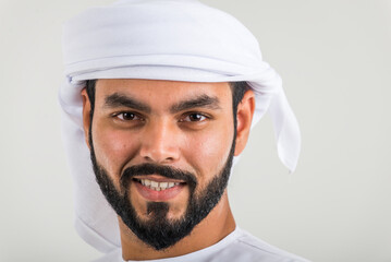 Handsome middle-eastern man wearing emirate traditional clothing portrait in studio