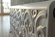 Radiator with white decorative flap box in the interior. Close-up of metal decorative radiator box with carved vintage patterns.