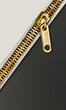 A golden zipper carving a line between black and grey textures.