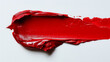 A swatch of bright red lipstick with rich color and smooth texture against a bright white background