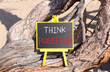 Think positive symbol. Concept words Think positive on beautiful black yellow blackboard. Beautiful tree background. Business, motivational think positive thinking concept. Copy space.