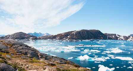 Wall Mural - Panoramic view of colorful Kulusuk village in East Greenland - Kulusuk, Greenland - Melting of a iceberg and pouring water into the sea