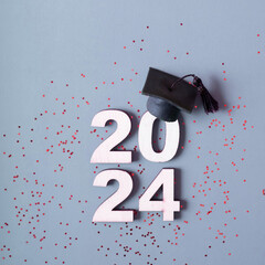 Wall Mural - Class of 2024 concept. Number 2024 with graduated cap and confetti
