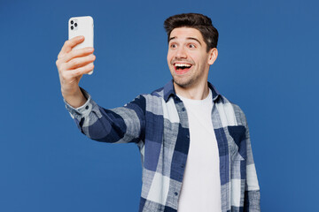 Wall Mural - Young Caucasian man wear shirt white t-shirt casual clothes doing selfie shot on mobile cell phone post photo on social network isolated on plain blue cyan color background studio. Lifestyle concept.